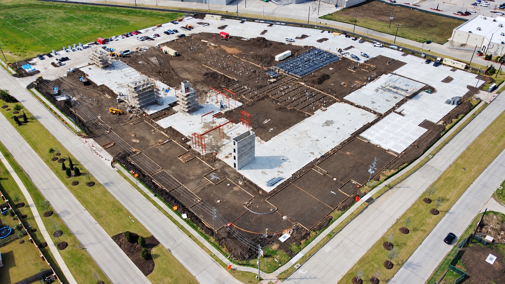 Aerial view of concrete slabs, foundations and rising structures at a BORN construction site